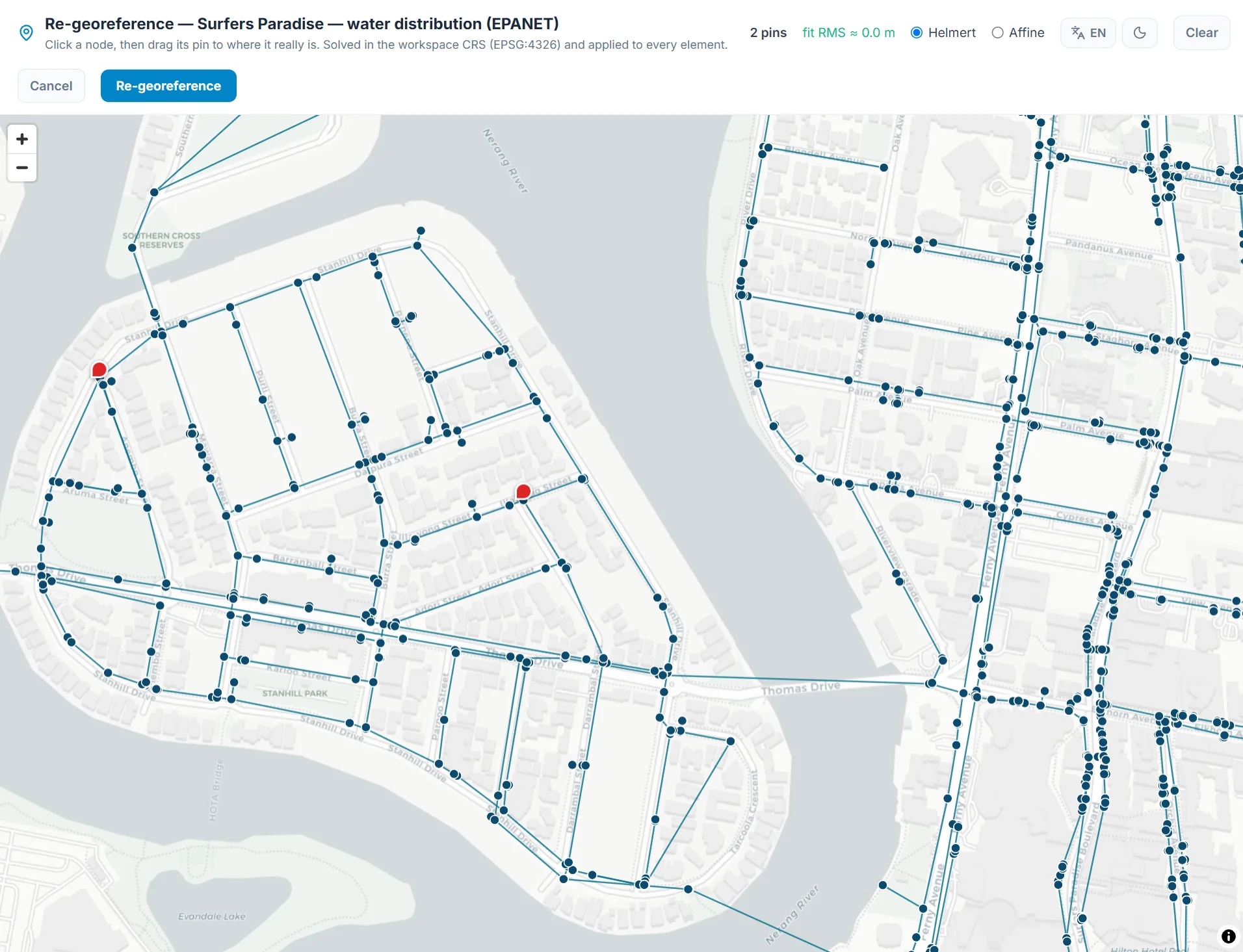 The HydroDSS re-georeference view: an EPANET network over the real basemap with two control-point pins, a live fit RMS readout, and a Helmert / affine transform toggle.